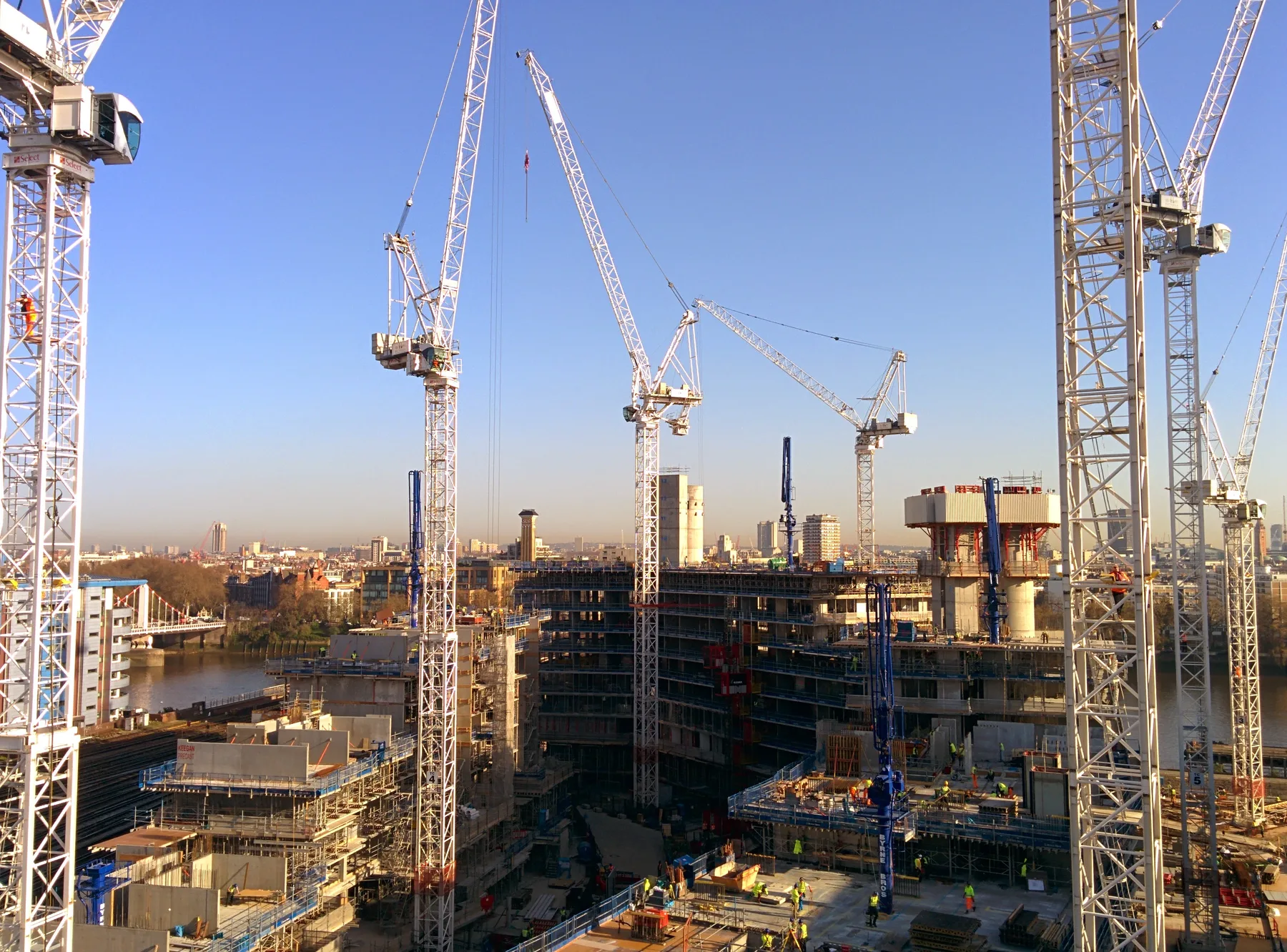 Tower cranes over a city site at dusk