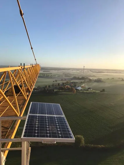 A tower crane at dawn — the solar-powered BCS option runs without mains power